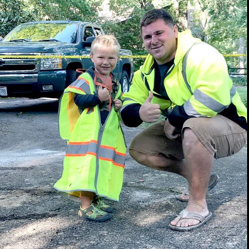 Concrete construction company owner poses with son
